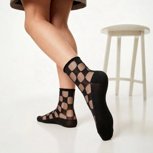 Sheer checkered socks worn by a person against a light background