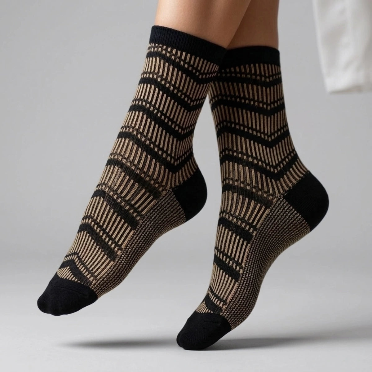 Patterned socks with black and gold design on a neutral background
