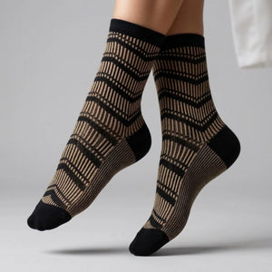 Patterned socks with black and gold design on a neutral background