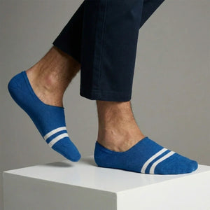 Blue no-show socks with white stripes worn by a person on a neutral background
