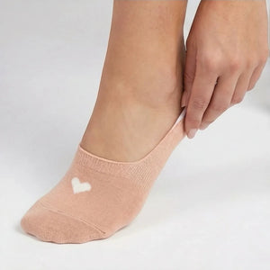 Person wearing a beige no-show sock with a cream heart design on a light grey background