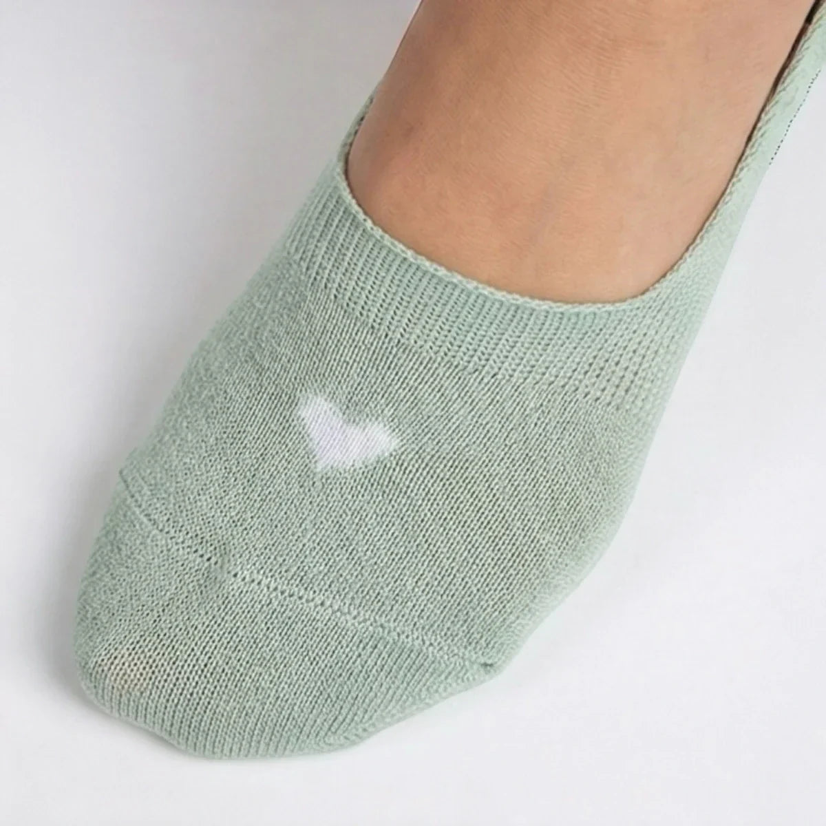 Mint no-show sock with a cream heart design on a light grey background