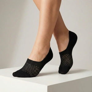 Black no-show socks with open-weave design worn against a light background