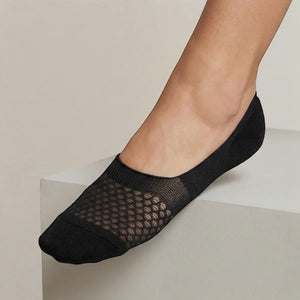 Black no-show sock with open-weave design worn against a light background