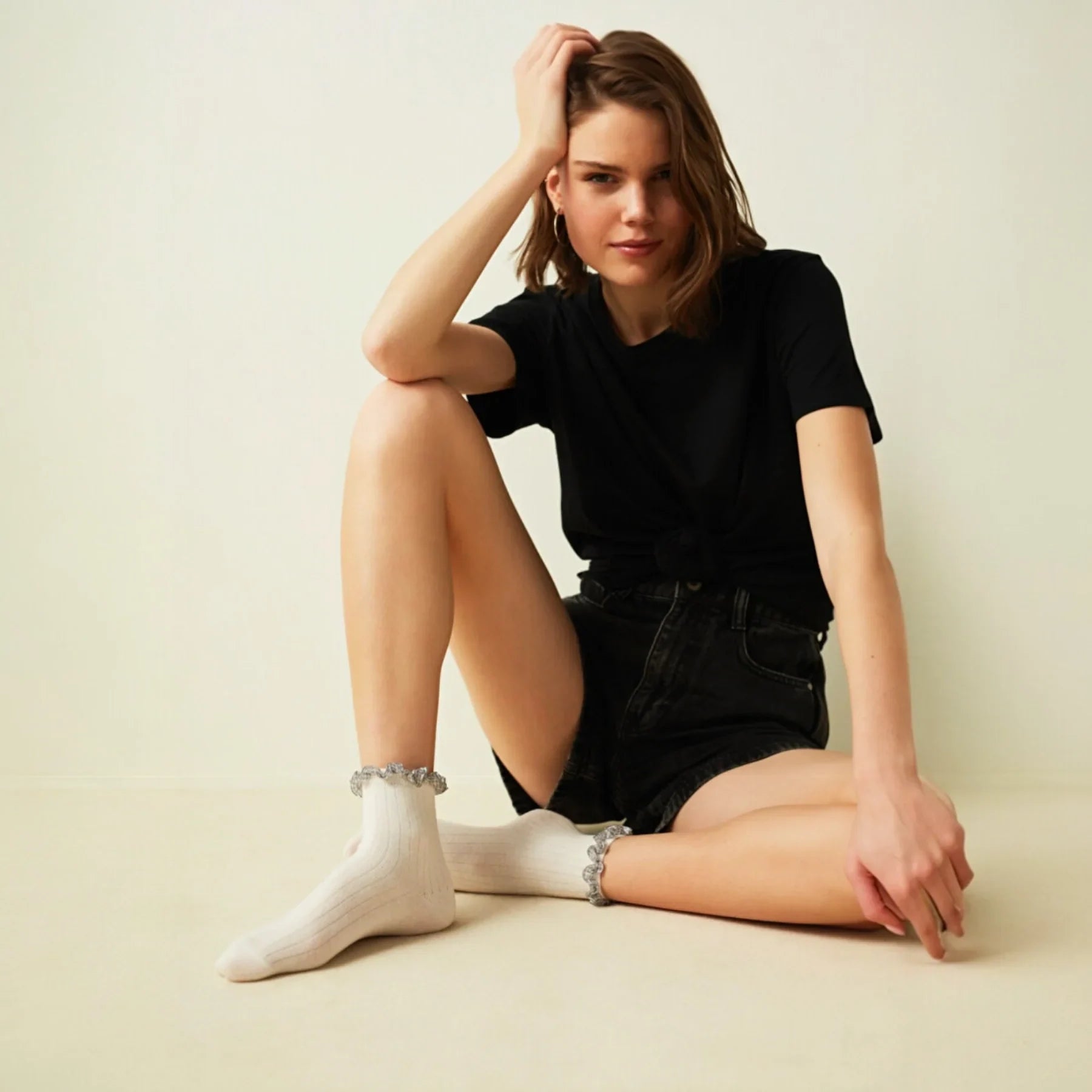 Woman wearing ivory ribbed quarter length socks with gingham ruffle