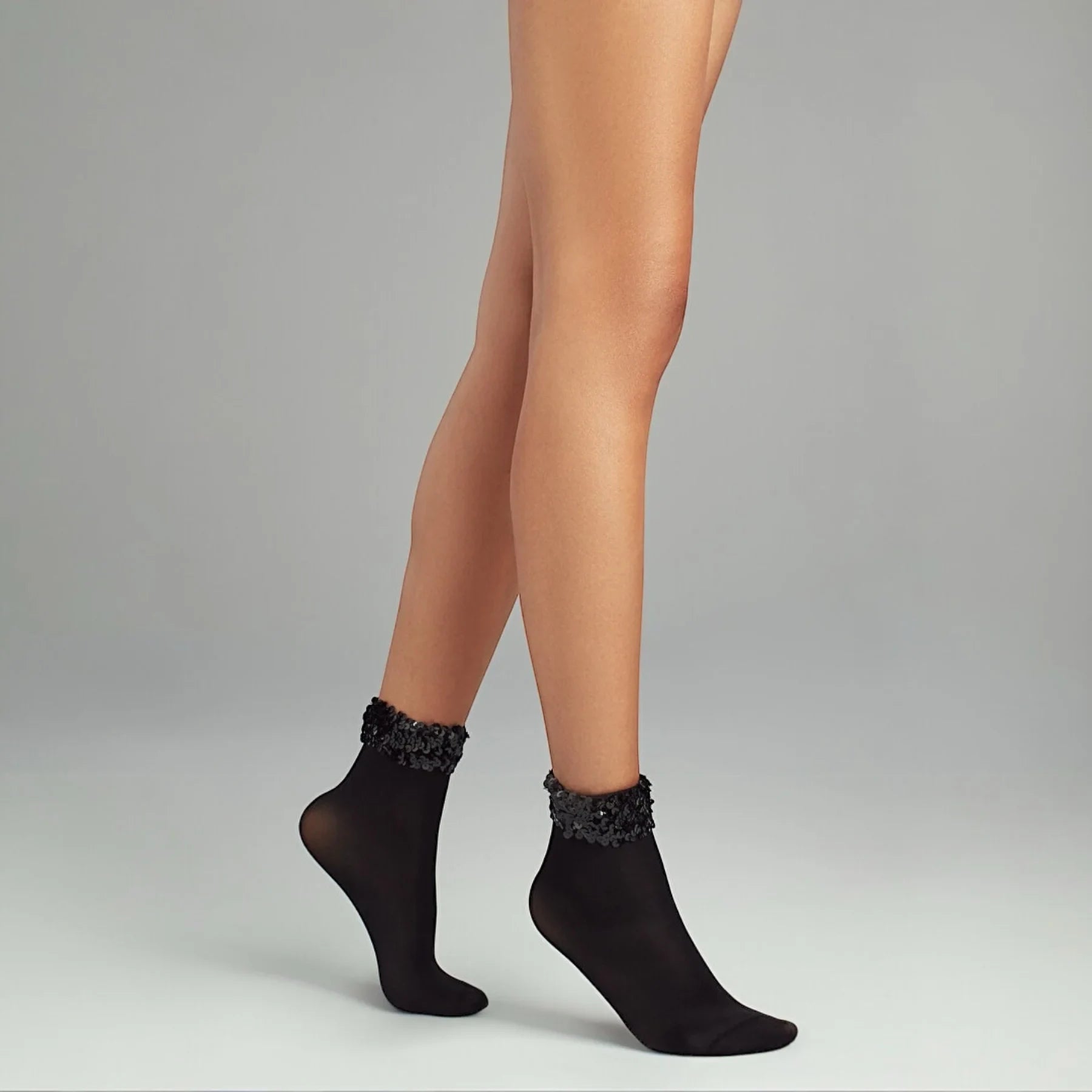 person wearing black quarter length socks with sequined cuff