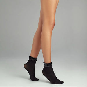 person wearing black quarter length socks with sequined cuff