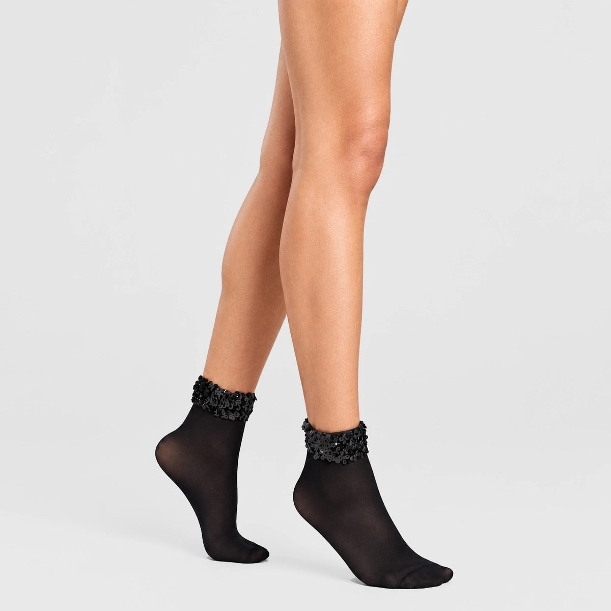 person wearing black quarter length socks with sequined cuff
