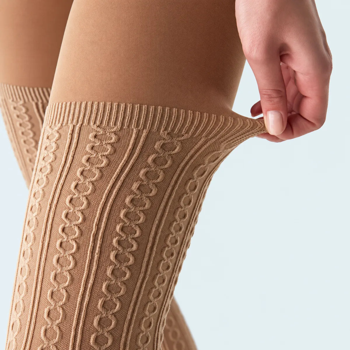 Close-up detail of beige fashion tights that appear like patterned thigh-high socks
