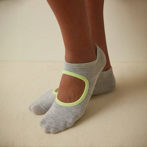 person wearing grey and yellow yoga socks