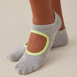 person wearing grey and yellow yoga socks