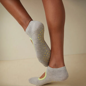 person wearing grey and yellow yoga socks