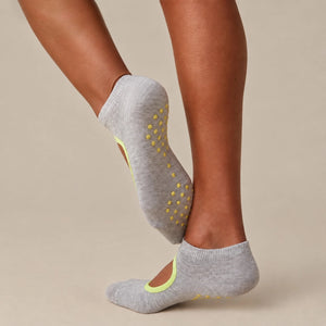 person wearing grey and yellow yoga socks