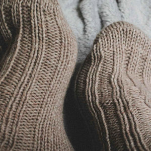 Person wearing beige alpaca and merino wool socks