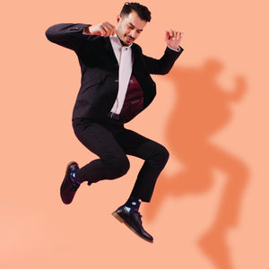 Man wearing navy socks with multiple coloured dots, toe and heel