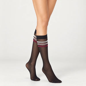 person wearing sheer black knee high socks with multicoloured striped cuff