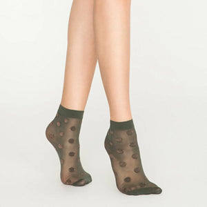 Person wearing sheer khaki ankle socks with rose gold dots