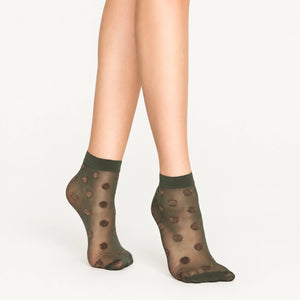 Person wearing sheer khaki ankle socks with rose gold dots