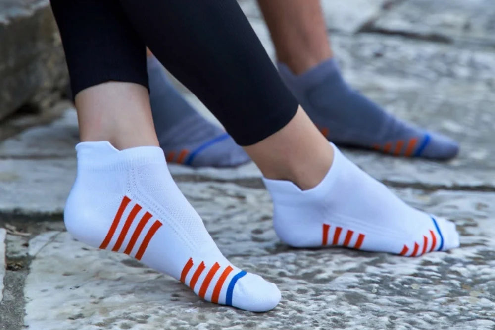 Person wearing white with coloured stripes bamboo sneaker socks