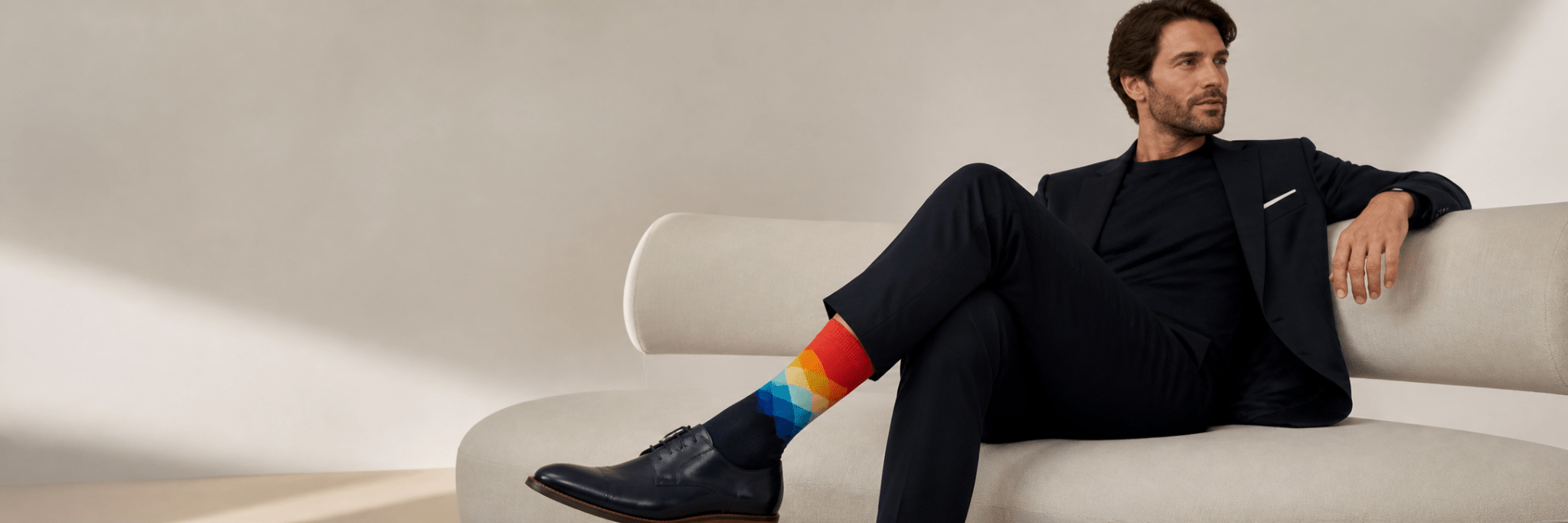 Men’s colourful crew socks styled with a smart casual outfit in a premium studio setting.