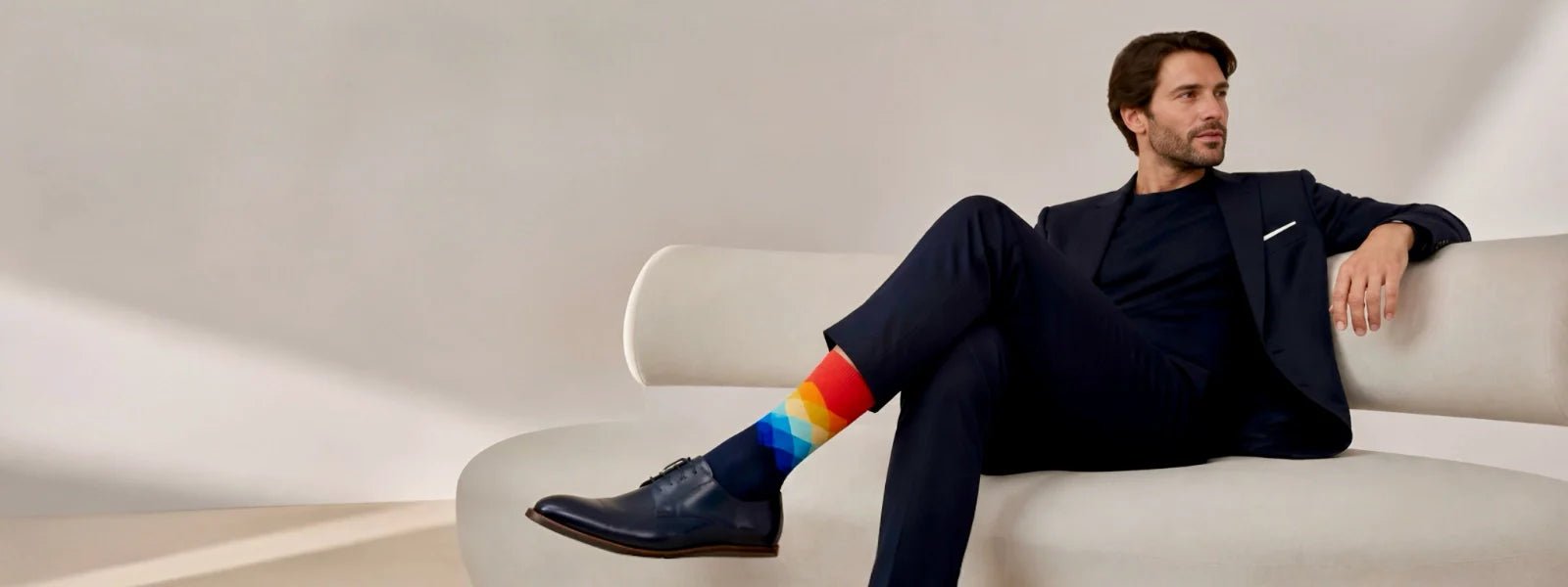 Men’s colourful crew socks styled with a smart casual outfit in a premium studio setting.