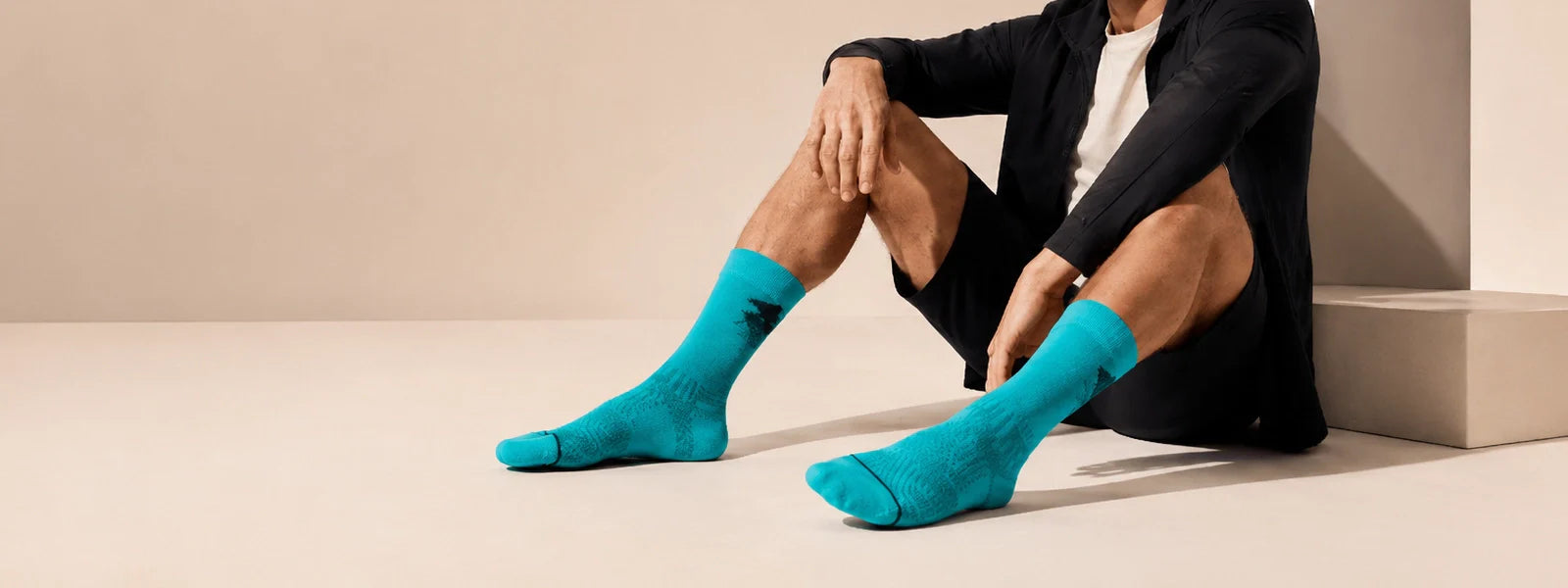 Men’s turquoise crew socks in a premium studio lifestyle setting