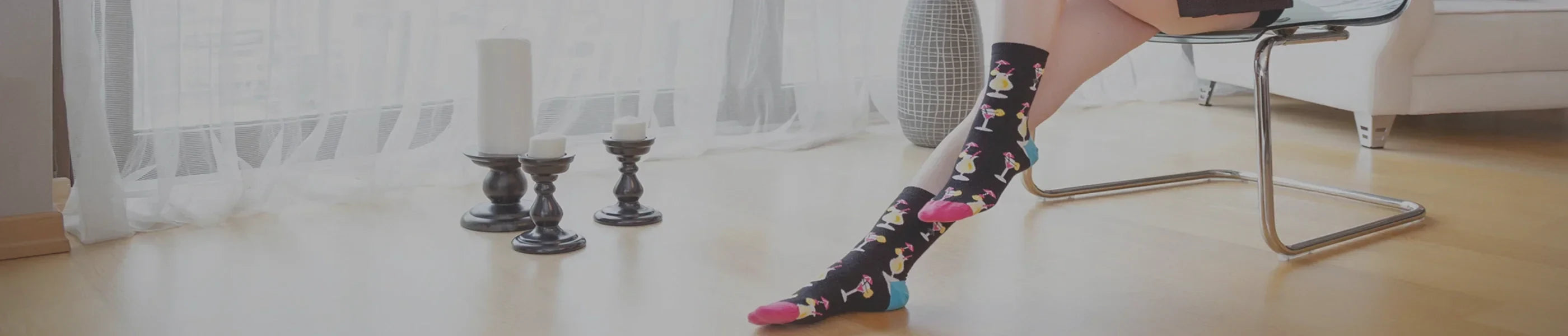 A woman wearing multicoloured crew socks sitting on a chair in a lounge room with timber floor