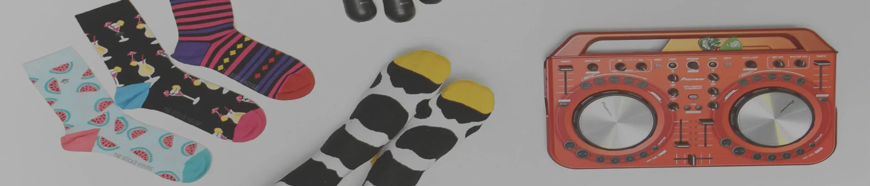 Four examples of multicoloured ladies crew socks and a vintage orange radio against a grey background