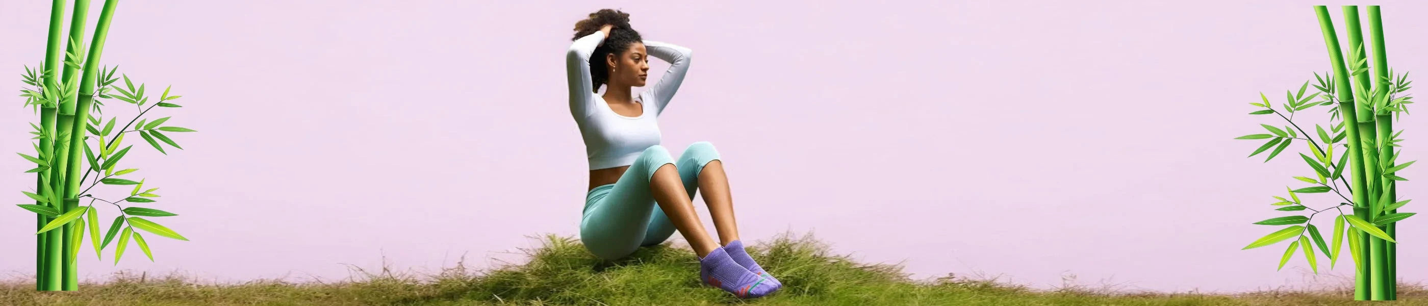 A woman in activewear wearing purple sneaker socks sitting on grass against a lilac and bamboo background