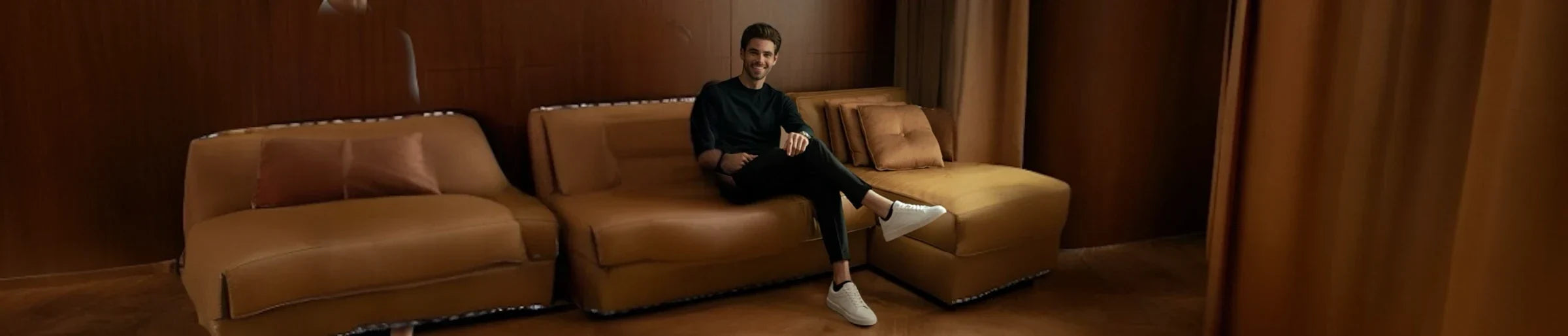 A man sitting on a brown leather lounge wearing cream ankle socks