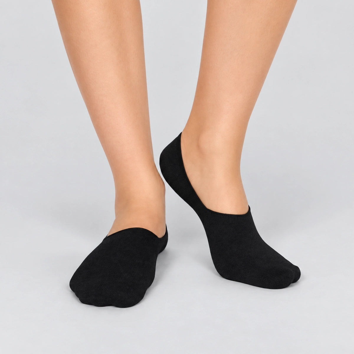 Person wearing charcoal no-show socks  on a white background