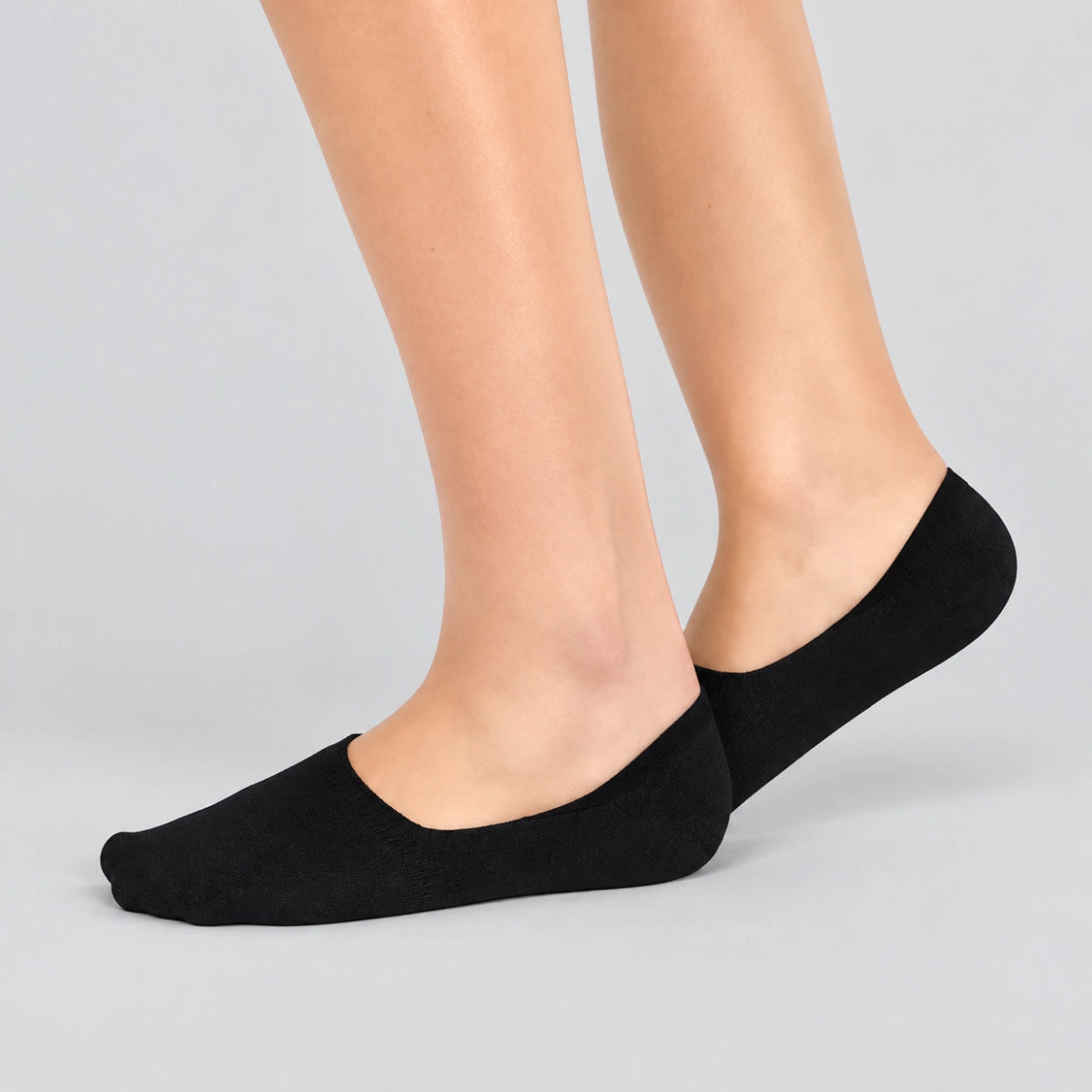 Person wearing charcoal no-show socks  on a white background