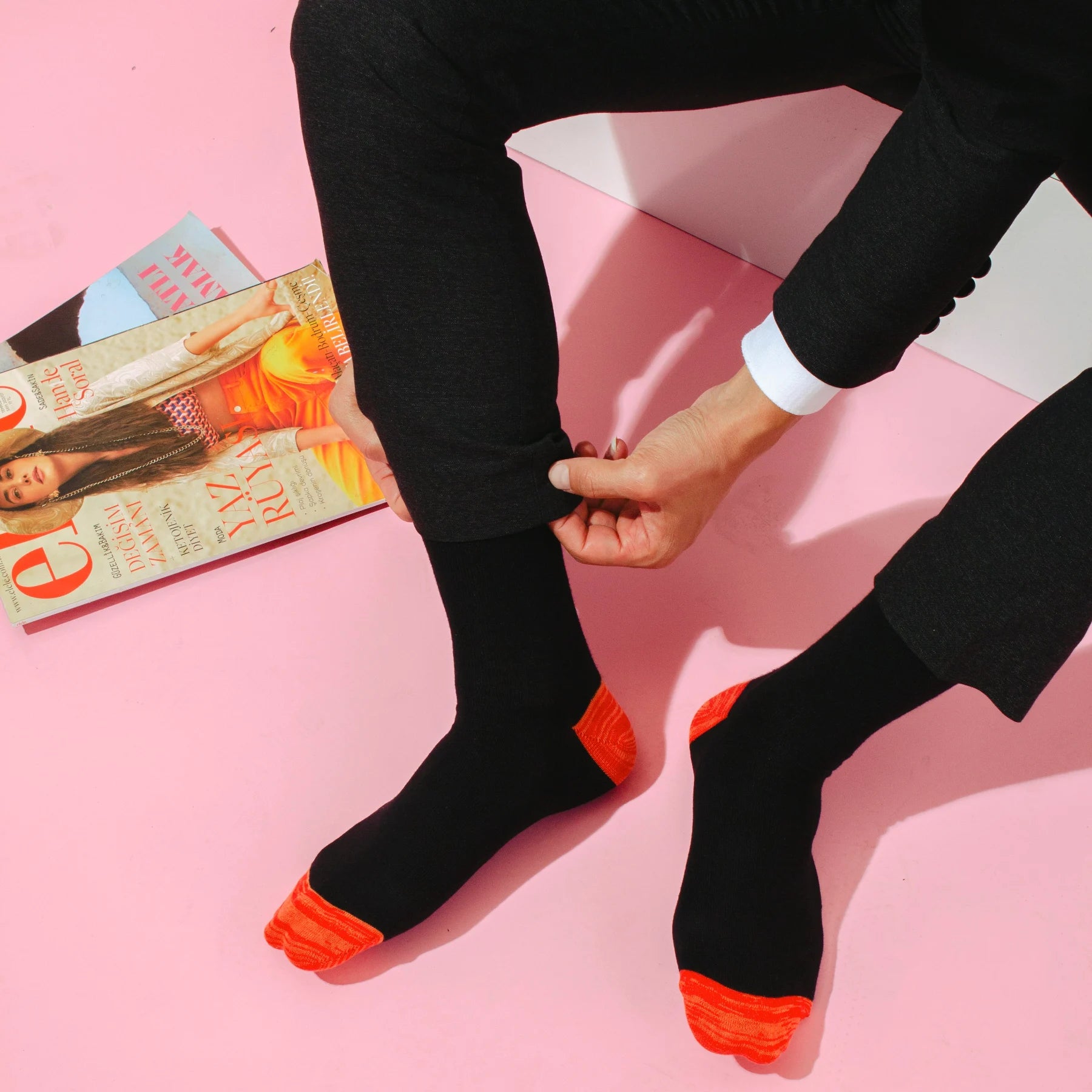 image of men's legs wearing dress pants and black socks with orange heel and toe detail