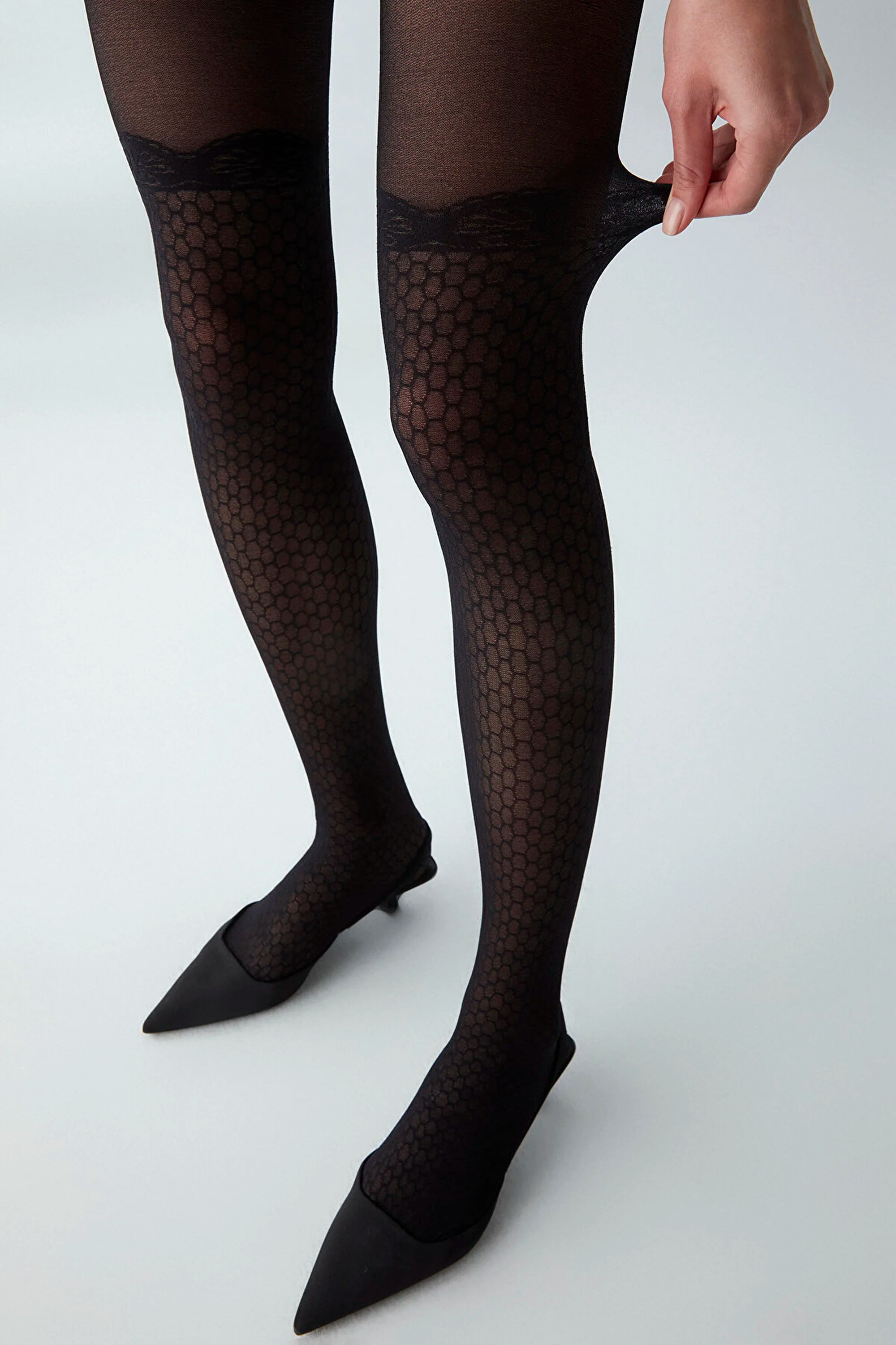 image of woman wearing black lace patterned pantyhose