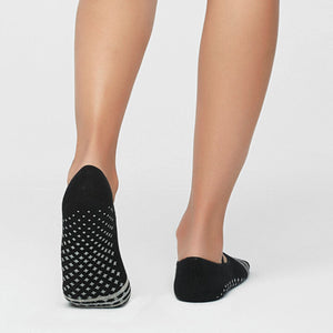 image of woman wearing black and stripe yoga socks