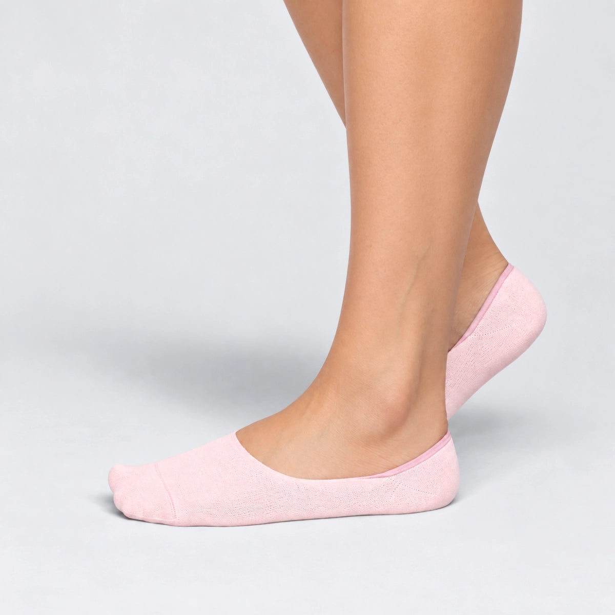 Person wearing seamless pink bamboo no-show socks on a white background