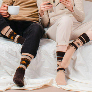 A man and a woman wearing brown and beige, Nordic patterned alpaca and merino wool socks