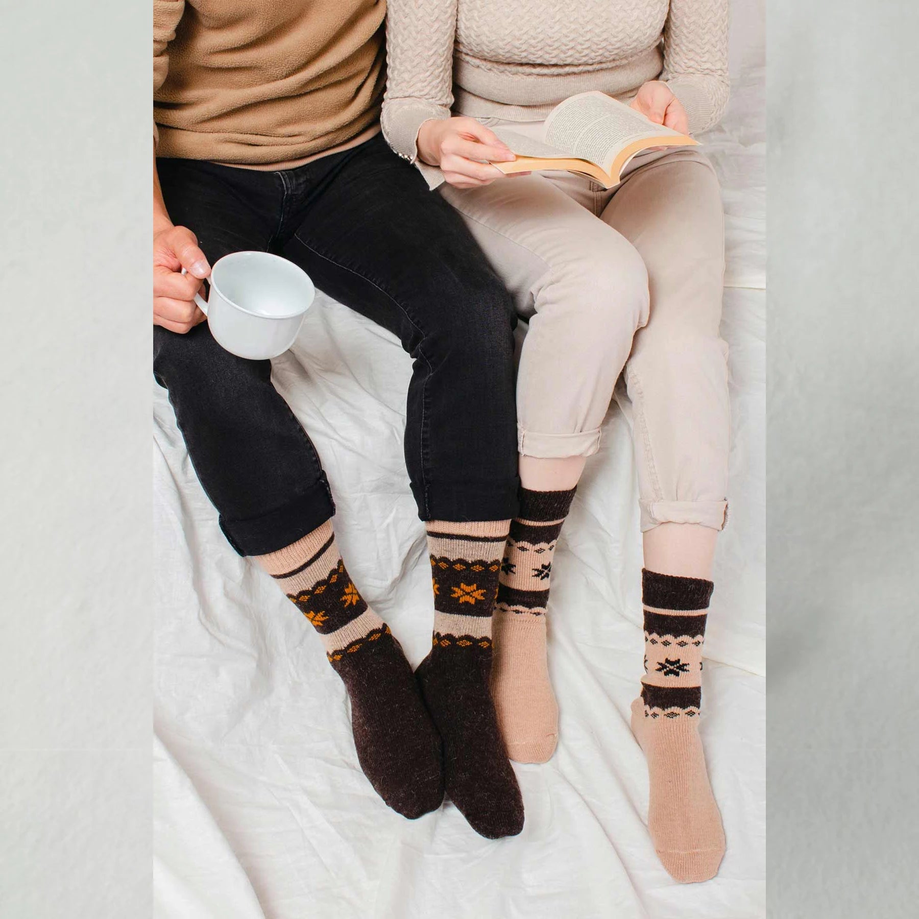 A man and a woman wearing brown and beige, Nordic patterned alpaca and merino wool socks