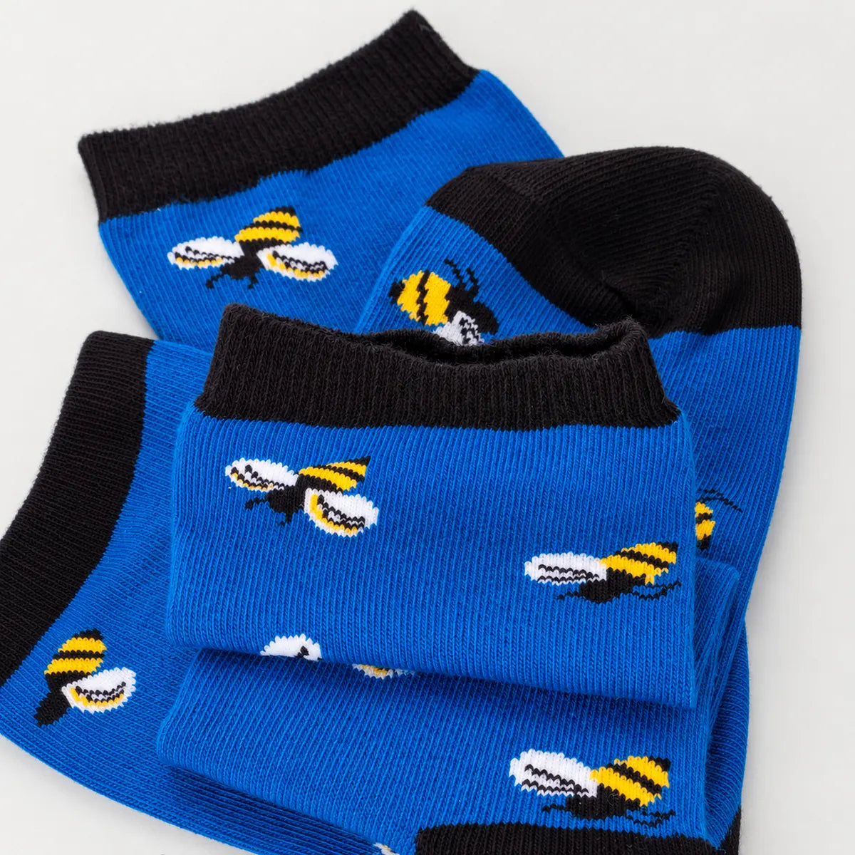 photo of light blue crew socks with honey bee images