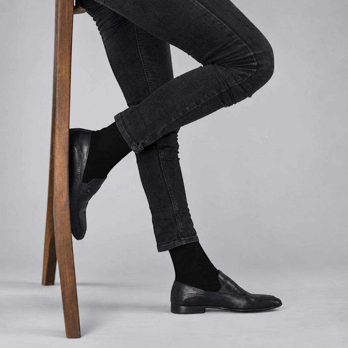 Black bamboo crew socks for men styled with slim jeans and leather shoes, premium breathable everyday socks by Uniq Socks