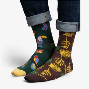 Mismatched socks with birds and leaves on a white background
