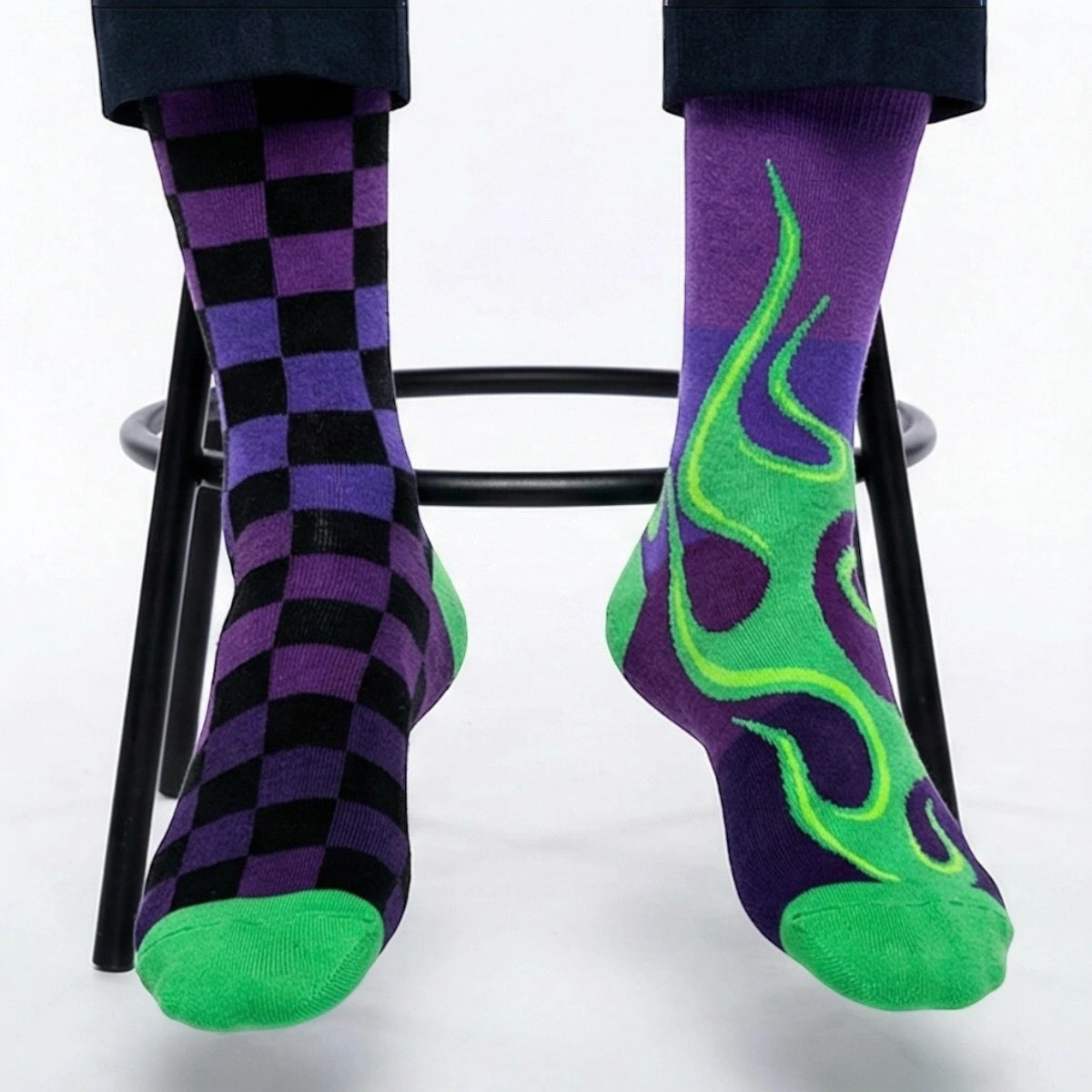 Mismatched purple and green checkered and flame-patterned socks on a white background