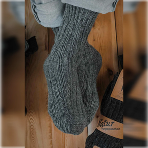 A person wearing plain grey Alpaca and merino wool socks