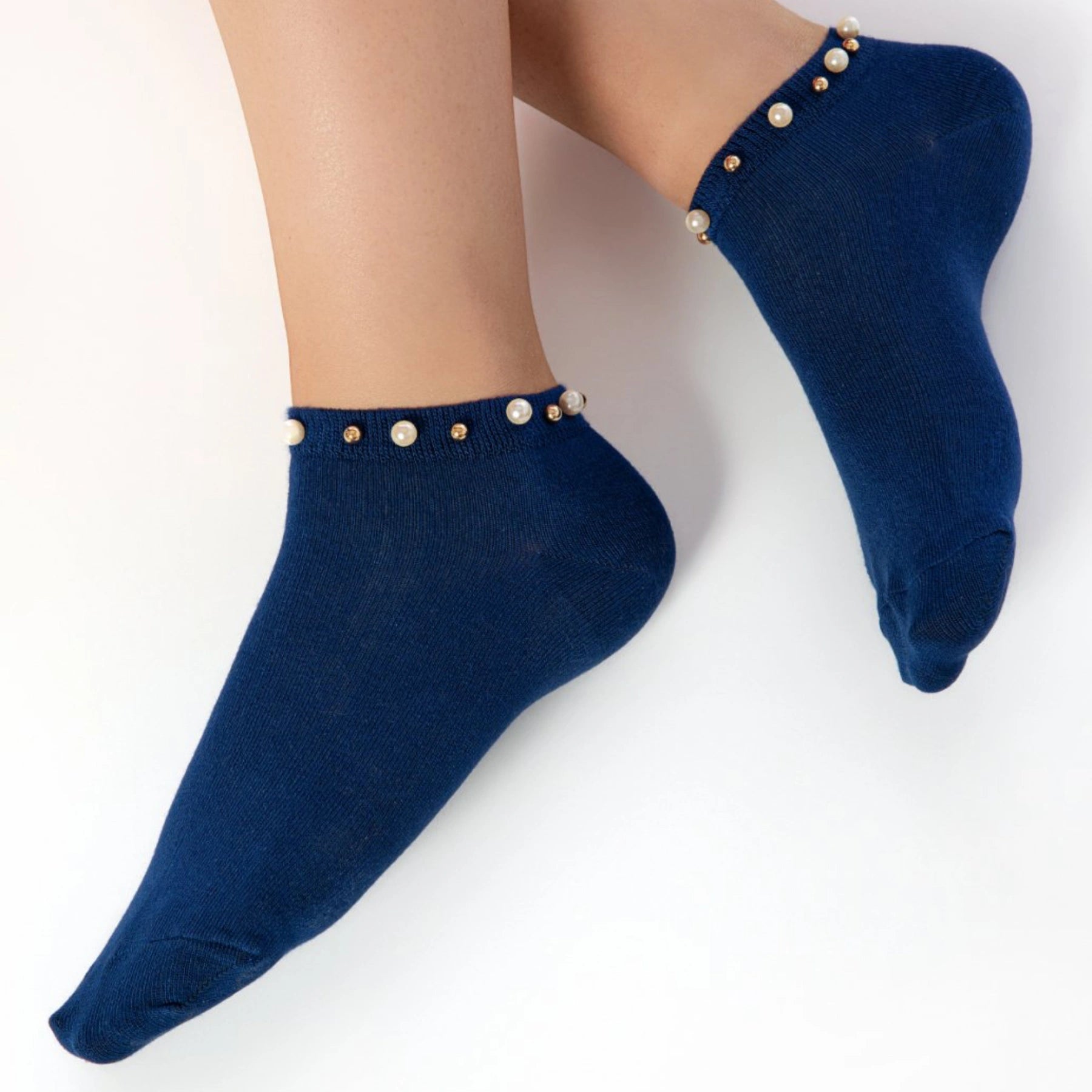 A woman wearing blue ankle socks embellished with pearls around the cuff