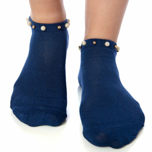 A woman wearing blue ankle socks embellished with pearls around the cuff