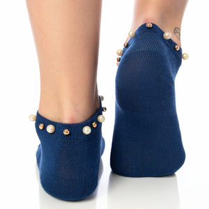 A woman wearing blue ankle socks embellished with pearls around the cuff