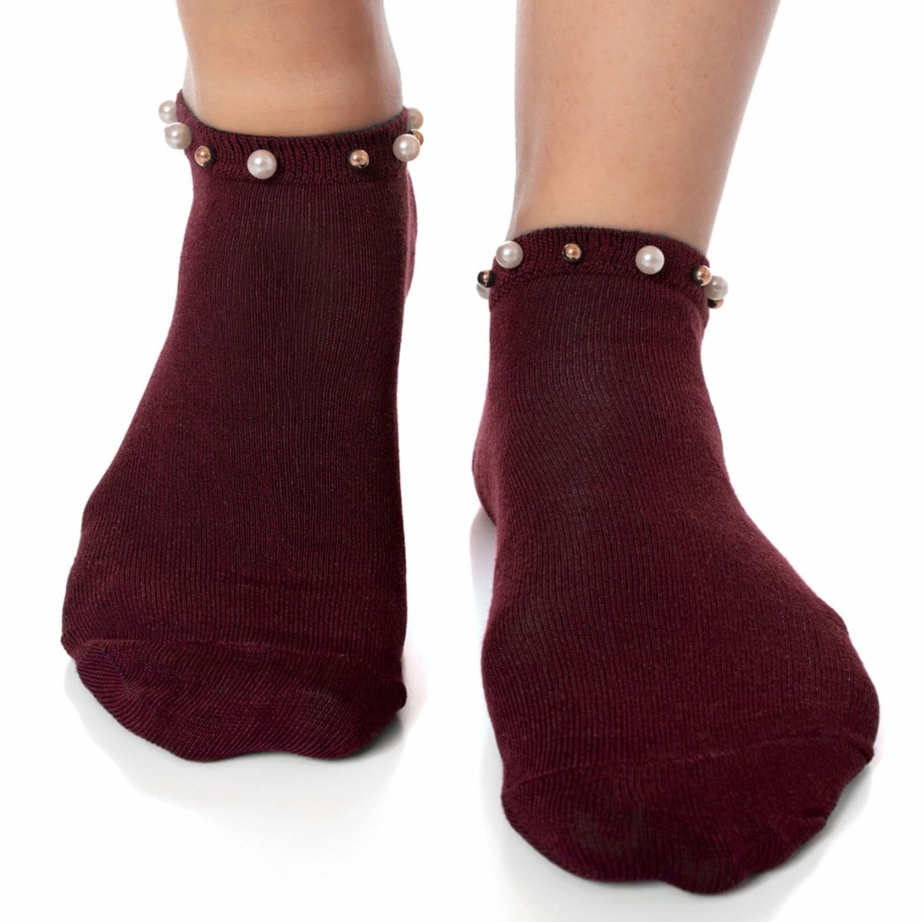 A woman wearing burgundy ankle socks embellished with pearls around the cuff