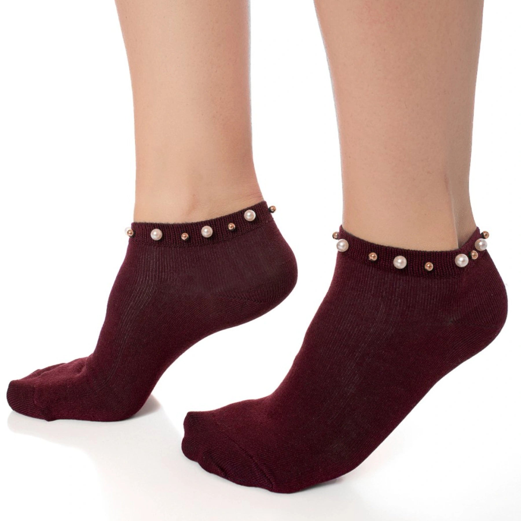 A woman wearing burgundy ankle socks embellished with pearls around the cuff