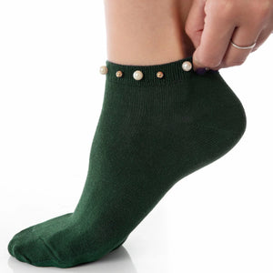 A woman wearing green ankle socks embellished with pearls around the cuff