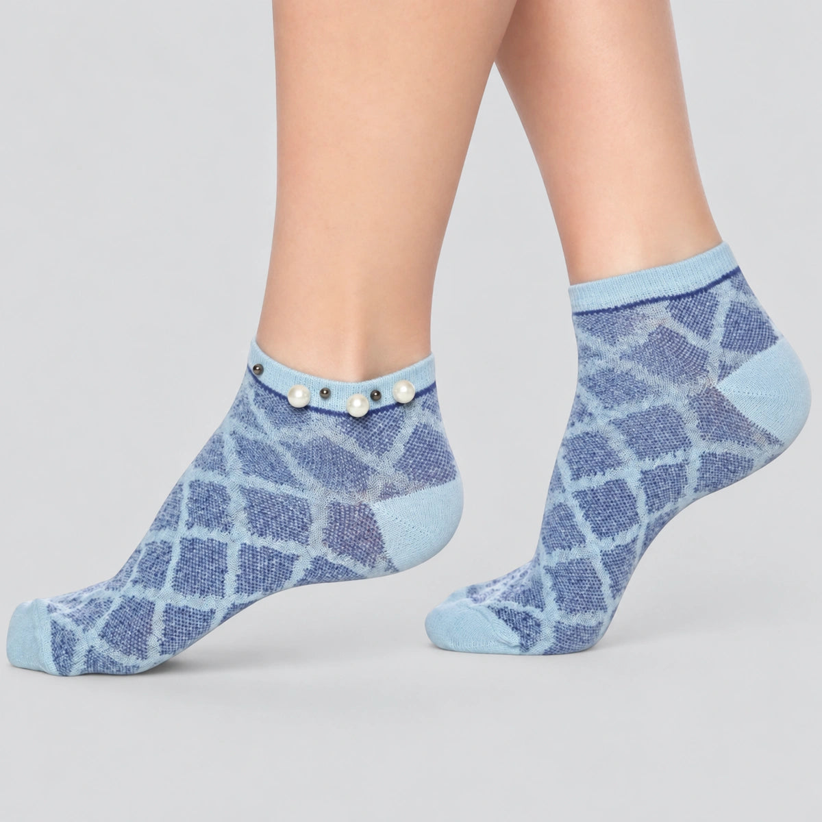 A woman wearing blue checked ankle socks finished with pearls around the cuff